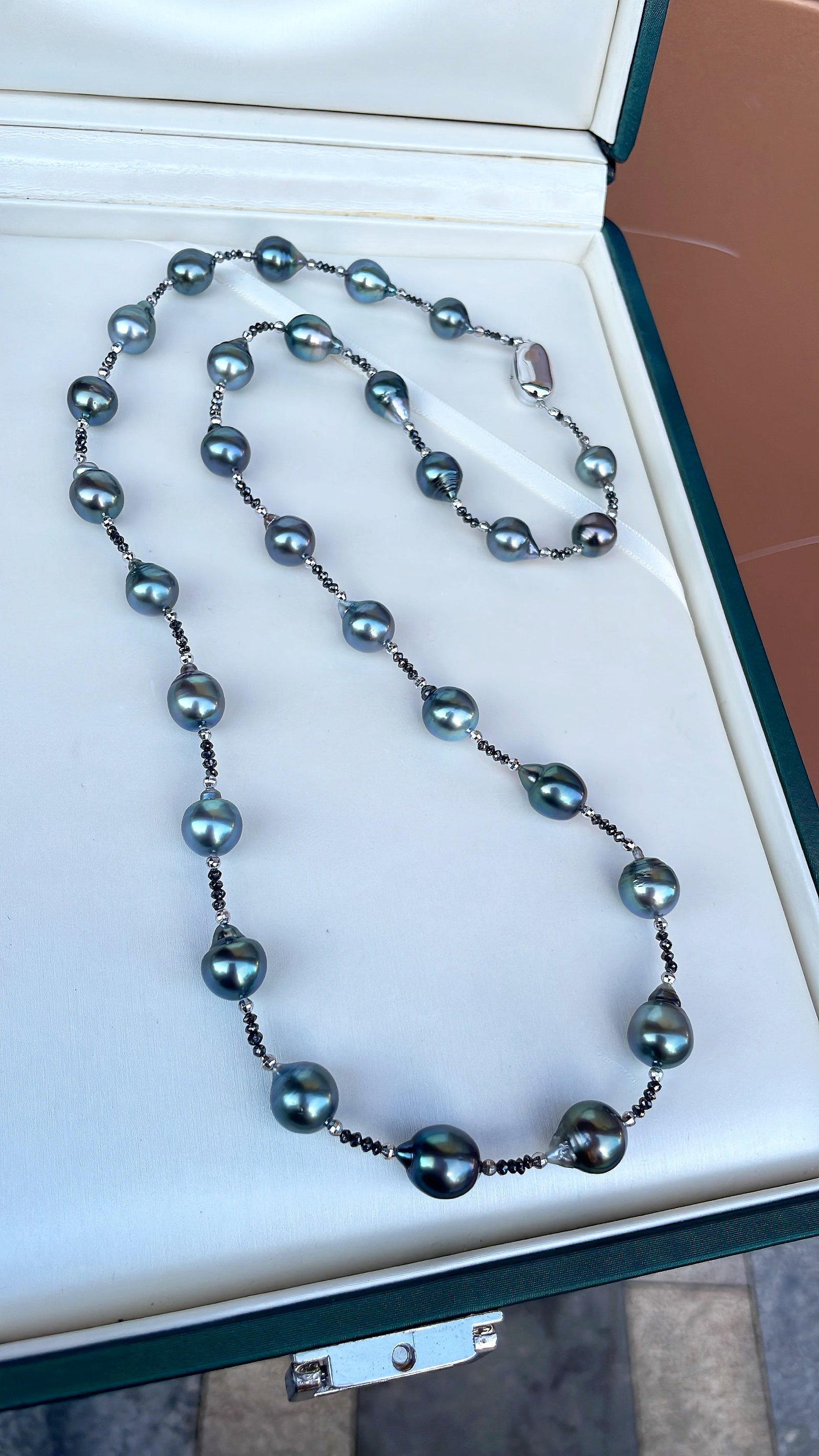 Natural Tahitian Black Pearl Long Necklace: This natural Tahitian black pearl long necklace is captivating with its full drop shape and intense luster. The pearls range from 8.9 to 10.9mm in diameter, featuring minor surface imperfections,