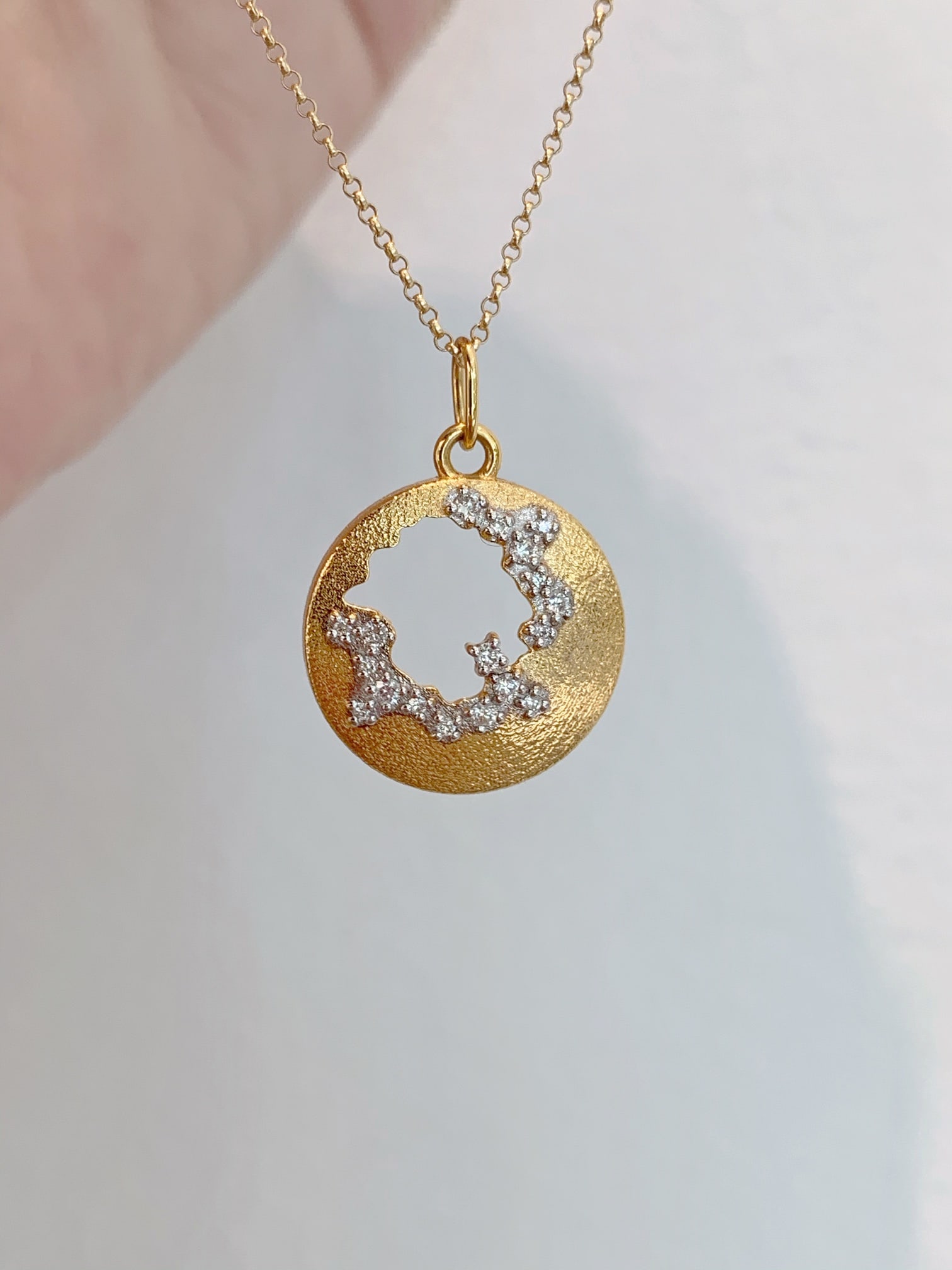 18K Gold Diamond Pendant: This 18K gold diamond pendant resembles a crescent moon, capturing the essence of a galaxy up close. The exquisite setting allows the diamond to sparkle beautifully under subtle light.