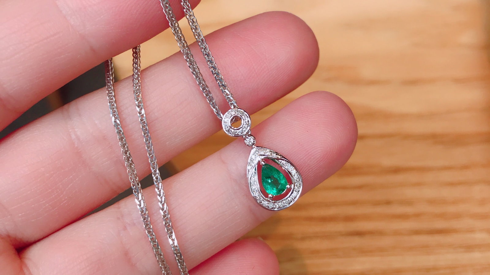 18K Gold Natural Emerald Pendant: This pendant is meticulously crafted in 18K gold, set with a natural emerald that exudes a captivating brilliance. Surrounded by 37 diamonds, it adds a touch of luxury. The overall design is elegant