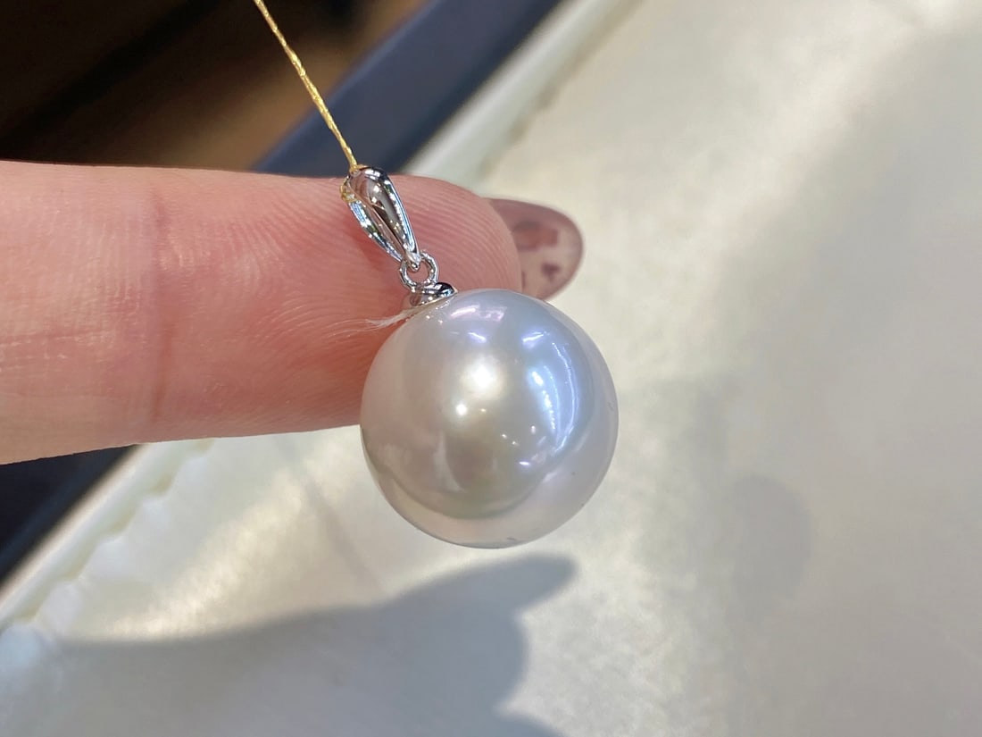 18K Gold Round Luster Freshwater Pearl Pendant: This pendant is meticulously crafted in 18K gold, featuring a 13-14mm round freshwater pearl that showcases its natural luster and unique slight blemishes. Suitable for various occasions, it exudes