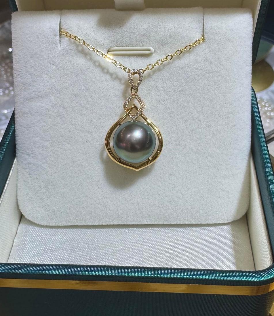 18K Gold Flawless Tahitian Black Pearl Pendant: This pendant is crafted from 18K gold, featuring a flawless Tahitian black pearl with a diameter of 11-12mm, showcasing an almost perfect round shape and strong luster. The pearl's surface has extreme