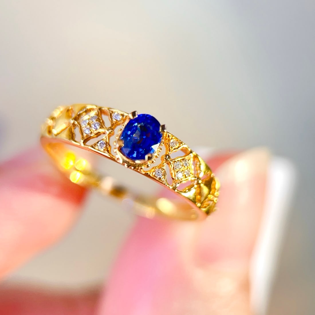 18K Gold Sapphire Ring: This ring is meticulously set in 18K gold, combining sapphire and diamonds to showcase an elegant style. The total weight is light, suitable for daily wear. The main stone is sapphire, surrounded by
