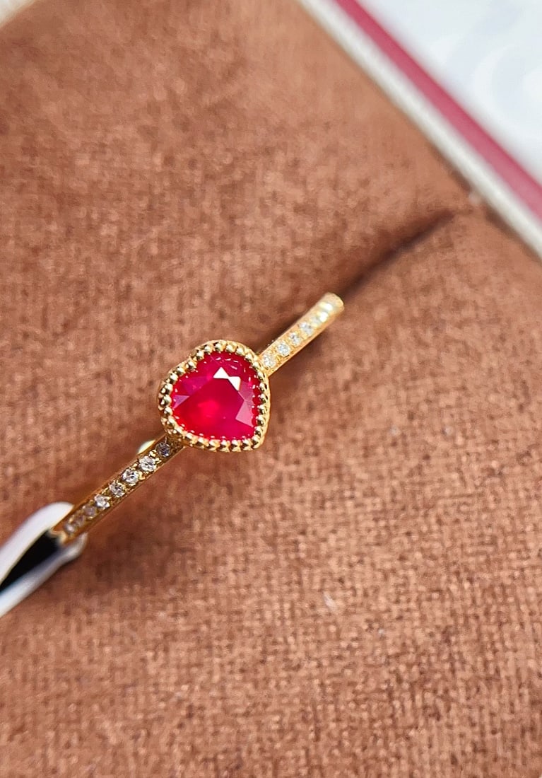 18K Gold Pigeon Blood Red Ruby Ring: This ring is meticulously crafted in 18K gold, featuring a heart-shaped cut pigeon blood red ruby, exuding elegance and nobility. It is adorned with 16 diamonds, adding a brilliant sparkle. The overal