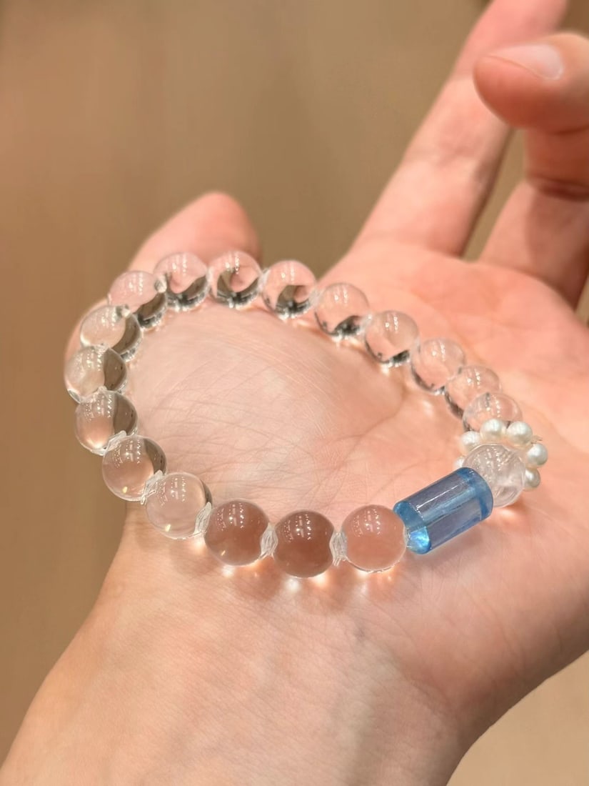 Natural White Crystal Bracelet: This bracelet features natural white crystal with a bead diameter of approximately 9mm, showcasing a clear and transparent texture. Paired with devil blue aquamarine barrel beads, it adds a touch of m