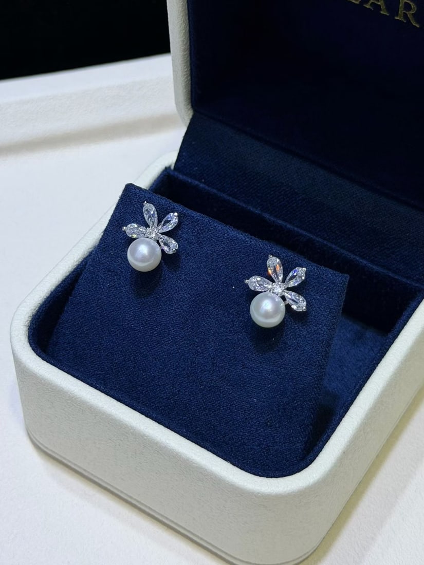 Sterling Silver Natural Freshwater Pearl Earrings: These earrings feature natural freshwater pearls with a diameter of 6-7mm, showcasing a perfectly round shape and strong luster. The nearly flawless pearls are complemented by meticulously crafted
