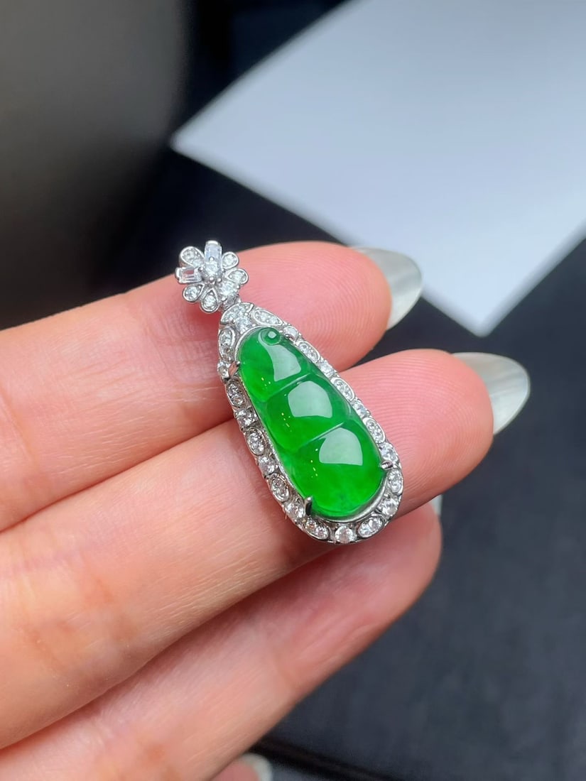 Silver Natural Jadeite Full Green Pendant: This jadeite pendant showcases a lush full green hue, a true gift from nature. The bean shape symbolizes good fortune, and the flawless craftsmanship is captivating. Wearing this pendant exudes
