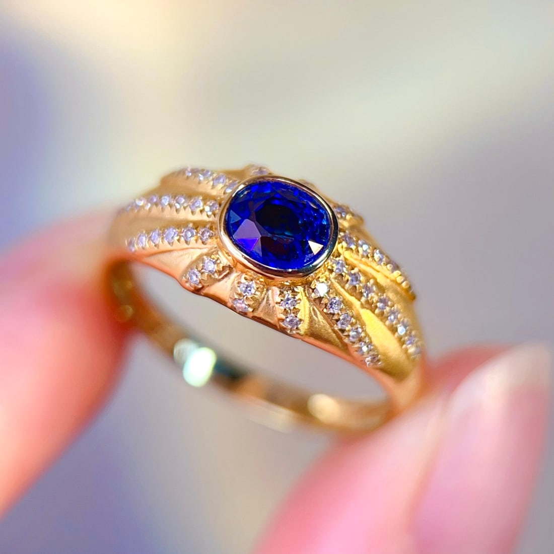 18K Gold Sapphire Ring: This 18K gold ring is set with a beautiful sapphire, surrounded by sparkling diamonds, showcasing a perfect blend of elegance and luxury. The ring's design is simple yet noble, suitable for various