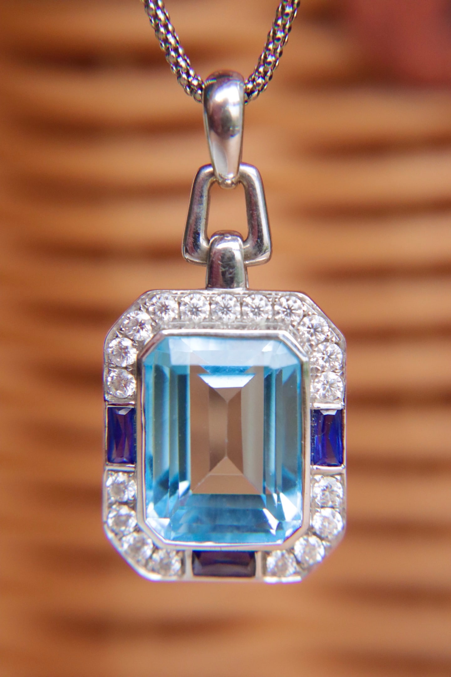 K Gold Aquamarine Color Topaz Pendant: This pendant is meticulously set in K gold, with the topaz showcasing an enchanting aquamarine hue. The main stone weighs 18 carats, exuding a luxurious heft.