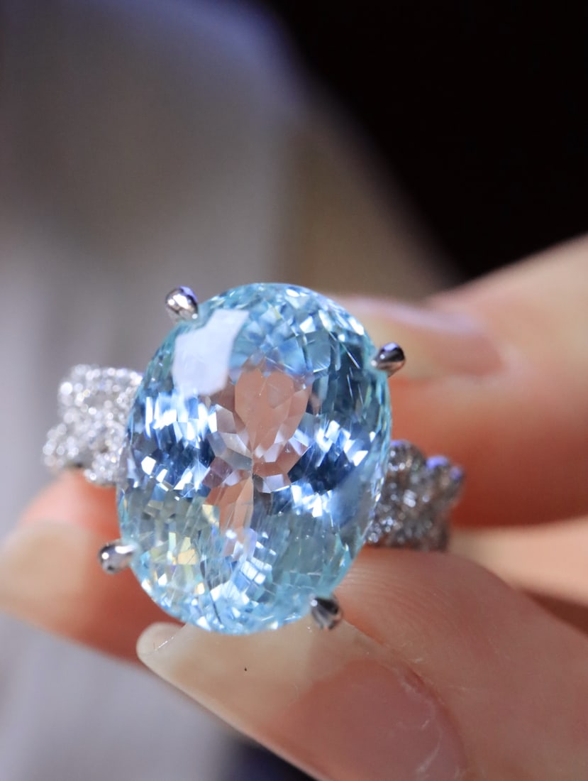 18K Gold Perfectly Cut Aquamarine Ring: This ring features a perfectly cut aquamarine set in 18K gold, showcasing a brilliant play of light. Its design is simple yet grand, exuding understated luxury. (Main stone 7.38 carats, diamonds 0.355