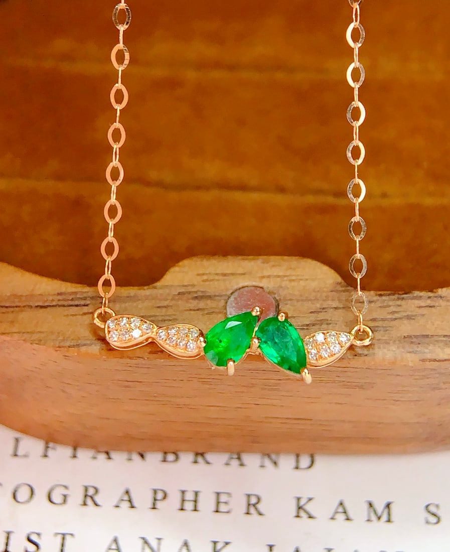18K Gold Natural Emerald Necklace: This necklace is meticulously crafted in 18K gold, featuring a natural emerald that perfectly combines elegance and luxury. Surrounded by 21 diamonds, it adds a brilliant sparkle. Suitable for any