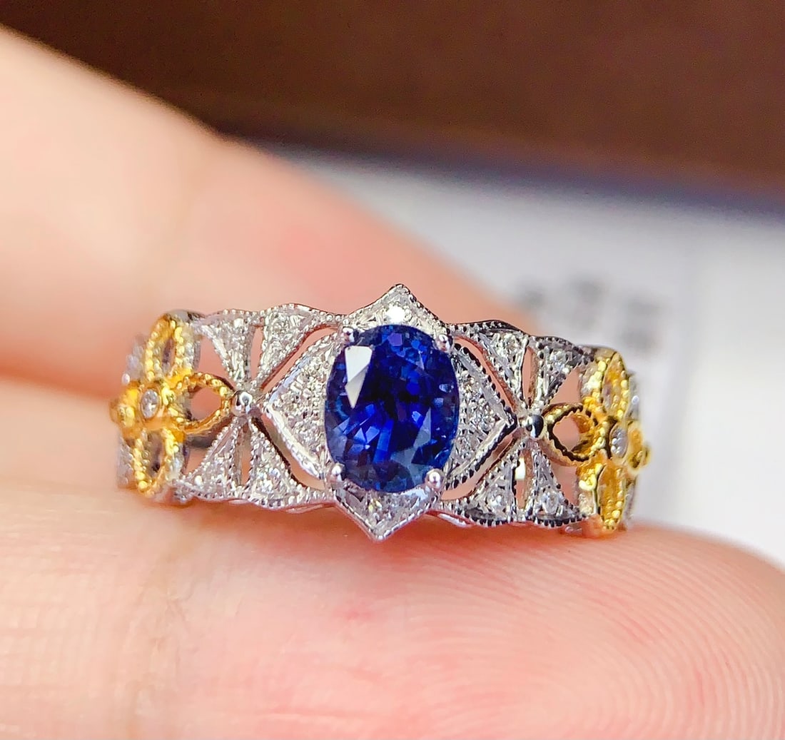 18K Gold Natural Sapphire Ring: This ring is meticulously crafted in 18K gold, set with a natural sapphire that exudes a captivating brilliance. The main stone's deep and pure blue is complemented by 22 sparkling diamonds, showcasin