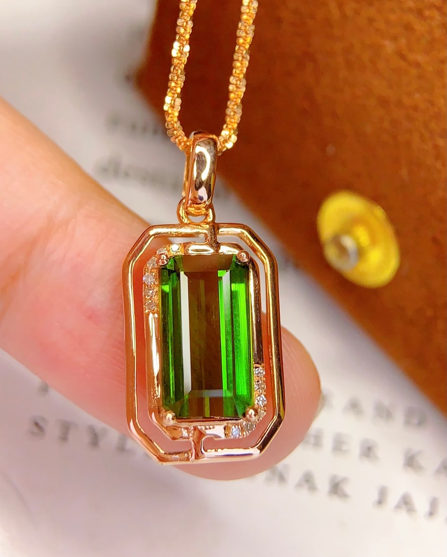 18K Gold Natural Tourmaline Pendant: This pendant is meticulously crafted in 18K gold, featuring a brilliant natural tourmaline that exudes an elegant and noble aura. The tourmaline's rich and captivating colors are complemented by 12 di