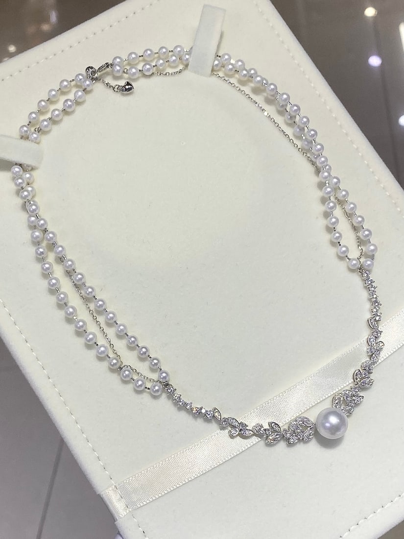 Australian White Pearl Necklace: This necklace features 10-11MM Australian white pearls, showcasing an almost perfect round shape. The finely crafted sterling silver woven design adds a unique sense of fashion. The slightly blemished