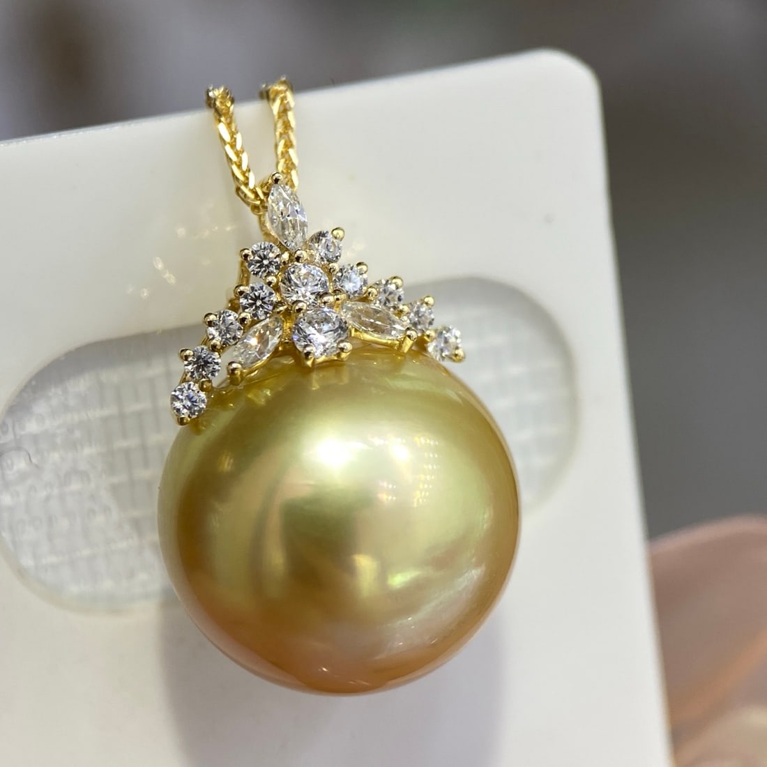 18K Gold Aurora Golden Pearl Pendant: This pendant is set in 18K gold, featuring a 15-16mm Aurora golden pearl with a perfectly round and nearly flawless quality. The pearl exhibits a unique golden-green luster, making it truly captivatin