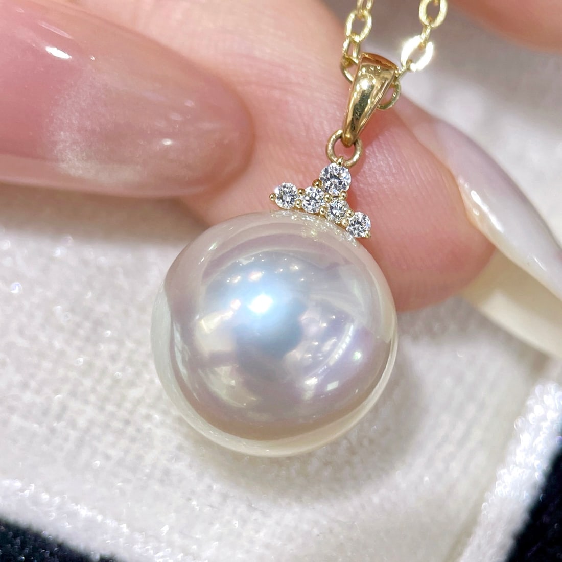 18K Gold Pearl Pendant: This pendant is crafted in 18K gold, featuring a pearl with iridescent aurora pink, as bright as a mirror, perfectly round with minimal blemishes. The pearl's surface is silky smooth, with a small sof