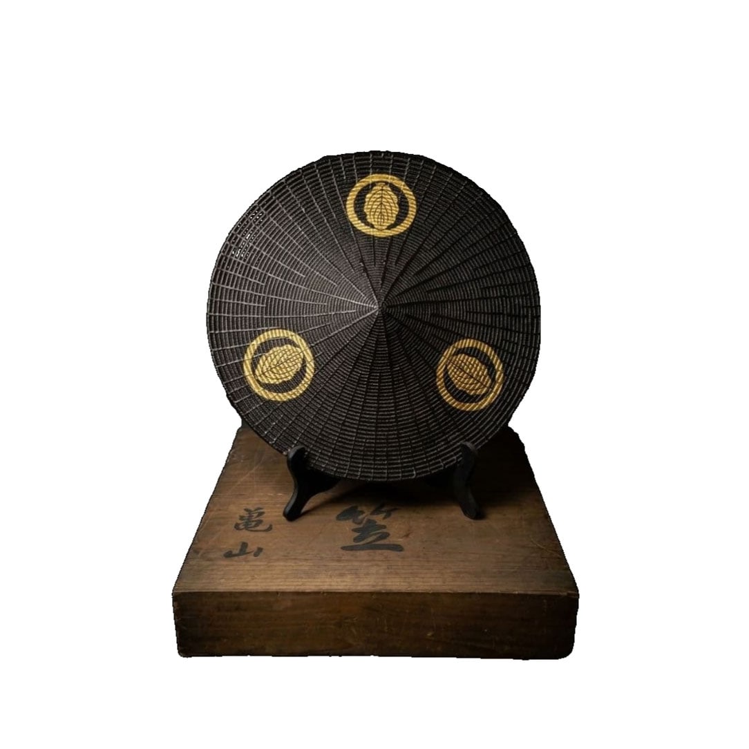 Edo Period Wajiro Jingasa, Circular, One Piece, Cypress with Gold Family Crest, Kameyama Ink: Edo Period Ajiro Jingasa, Circular with Ichimonji Kashiwa Family Crest in Gold, Kameyama Ink Inscription with Original Box, Accompanied by Wooden Stand A complete set of Edo Period Ajiro Jingasa. The 