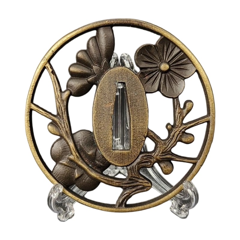 Tsuba with Plum Blossom Design, Alloy, Modern Piece: Tsuba with Plum Blossom Design, Alloy, Modern Piece Material: Alloy. Weight: Approximately 89 grams. Thickness: Approximately 6 millimeters. The item is only the tsuba; the sword stand is used for pho