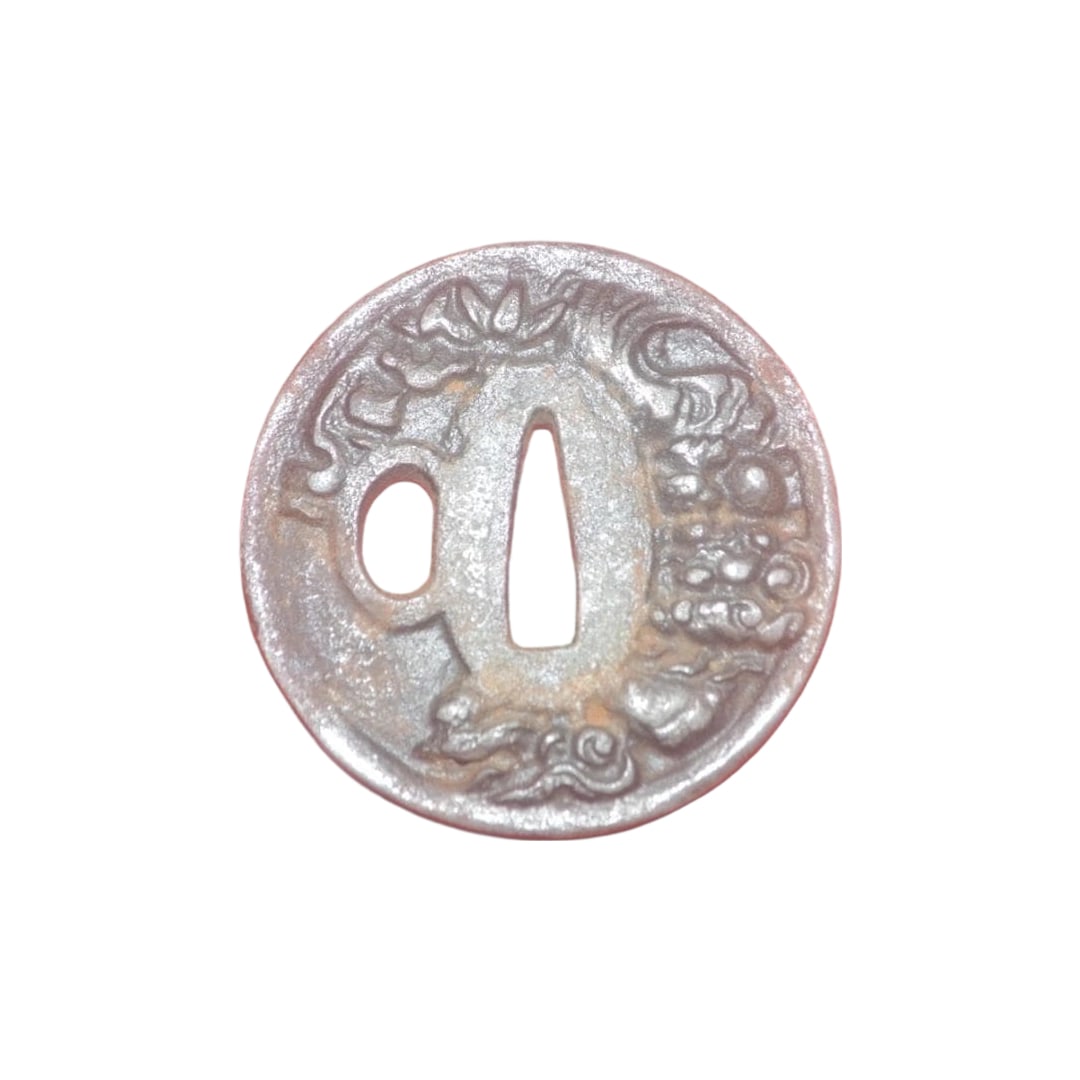 Tsuba: This is a tsuba (sword guard), approximately 6.9 centimeters in length and about 5 millimeters in thickness.