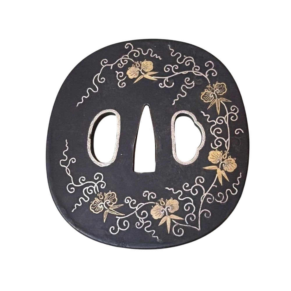 A black ground gold tsuba with plant and arabesque patterns depicted in flat inlay of gold and: A black ground gold tsuba with plant and arabesque motifs depicted in flat gold and silver inlay. This is a Japanese sword tsuba made of black ground gold, featuring plant and arabesque motifs express