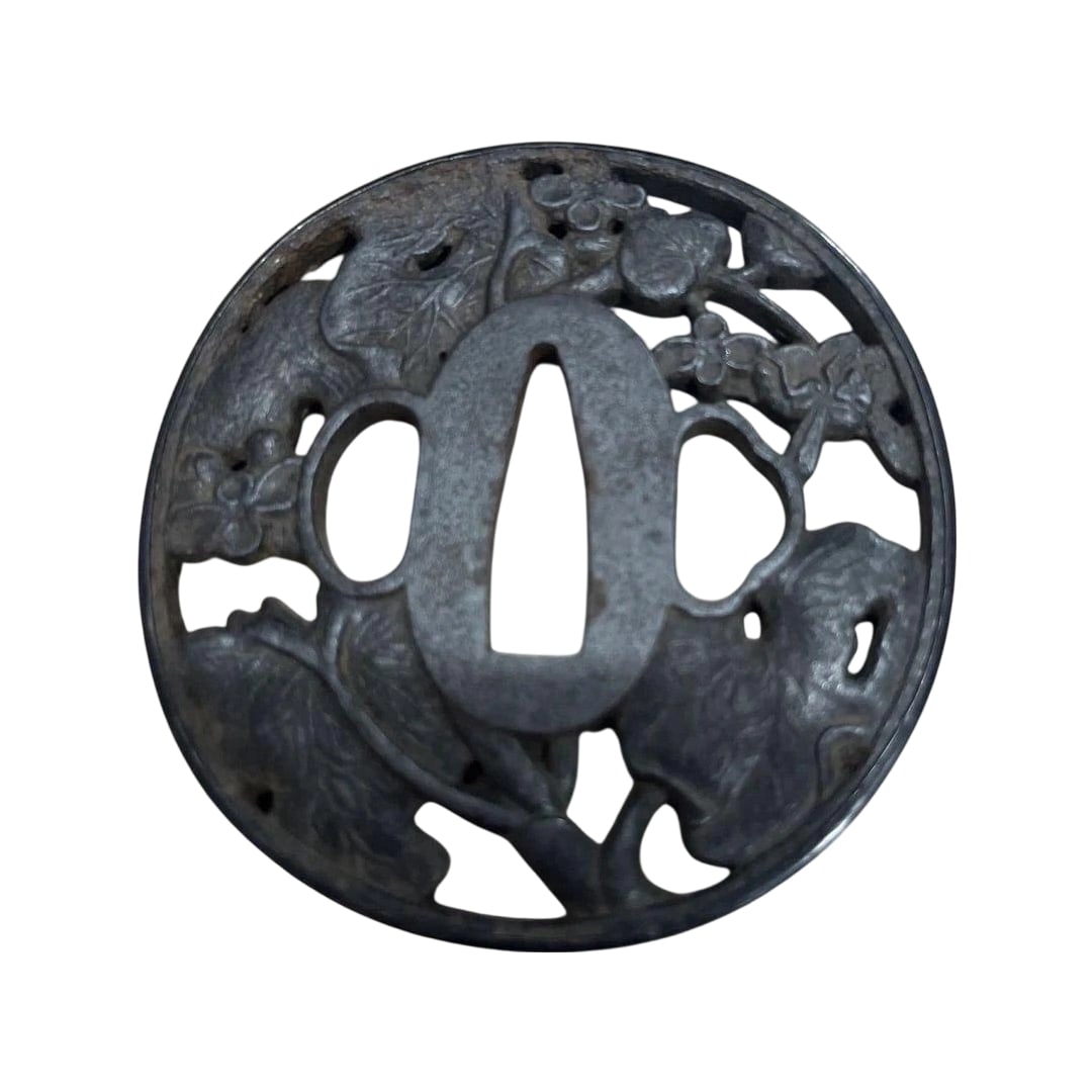 Carving of Plants and Animals, E.: Carved Plants and Animals Tsuba This is a circular metal tsuba, adorned with intricate carvings of plants and animals. It is used as an ornament for weaponry.