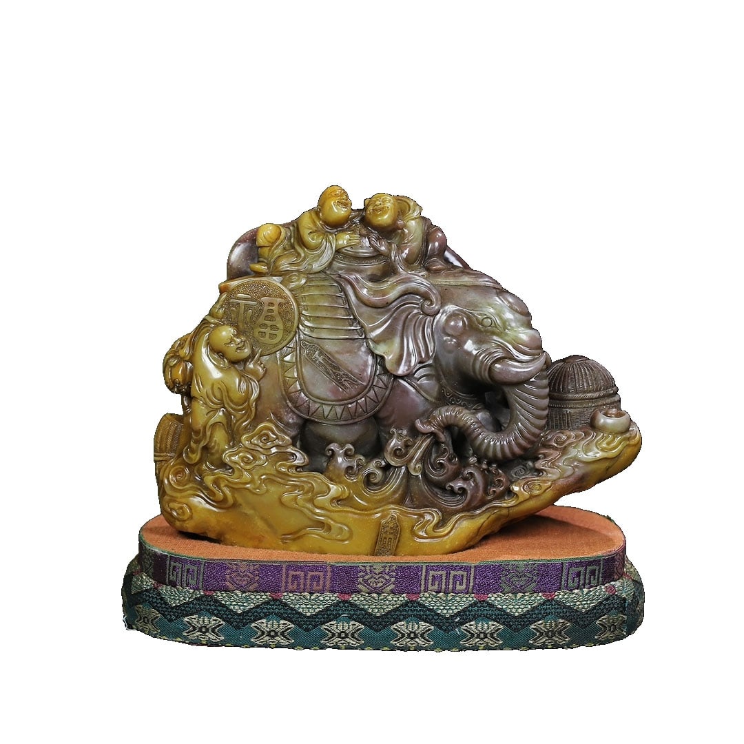 Shoushan Stone Carved 'Peaceful Elephant and Child' Seal Ornament: This Shoushan stone seal ornament showcases the auspicious theme of 'Peaceful Elephant and Child' through exquisite color carving techniques. The stone is smooth and fine, with superb craftsmanship,