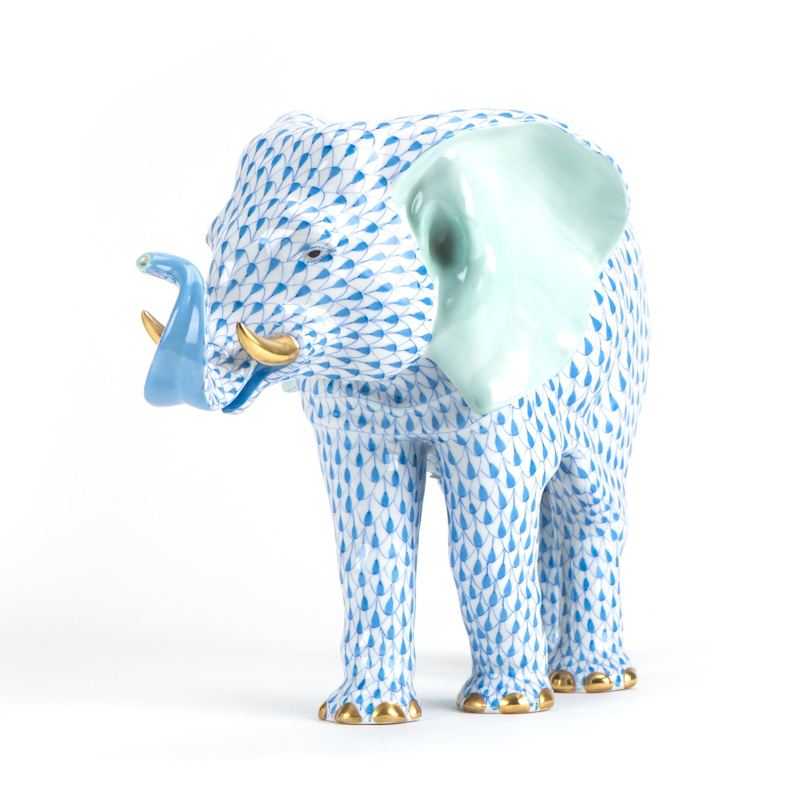 Herend Tierfigur Elefant im 'Fischnetz-Dekor': Herend Tierfigur Elefant im 'Fischnetz-Dekor' Herend, Ungarn, 20. Jh., Fischnetz-Dekor in blau, jeweils Porzellan, weiß, polychrom bemalt, gold staffiert, Höhe 26 cm, unterseitig Manufakturm