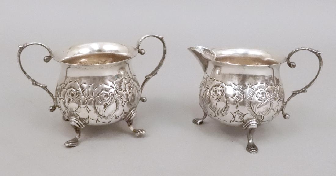 Baldwin & Miller sterling sugar and creamer: Baldwin & Miller sterling silver sugar and creamer, hand chased floral design, hoof feet, hallmarked on bottom "B&M, Sterling, 5, hand chased", sugar bowl measures 3 1/4" x 4 3/4", creamer measures 3 