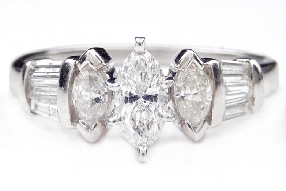 Platinum and diamond solitaire engagement ring: Platinum and diamond solitaire engagement ring, center marquise shaped diamond measuring approximately 0.25 carats, one 0.15 carat marquise shaped diamond on either side, and 0.15 carats of baguettes 