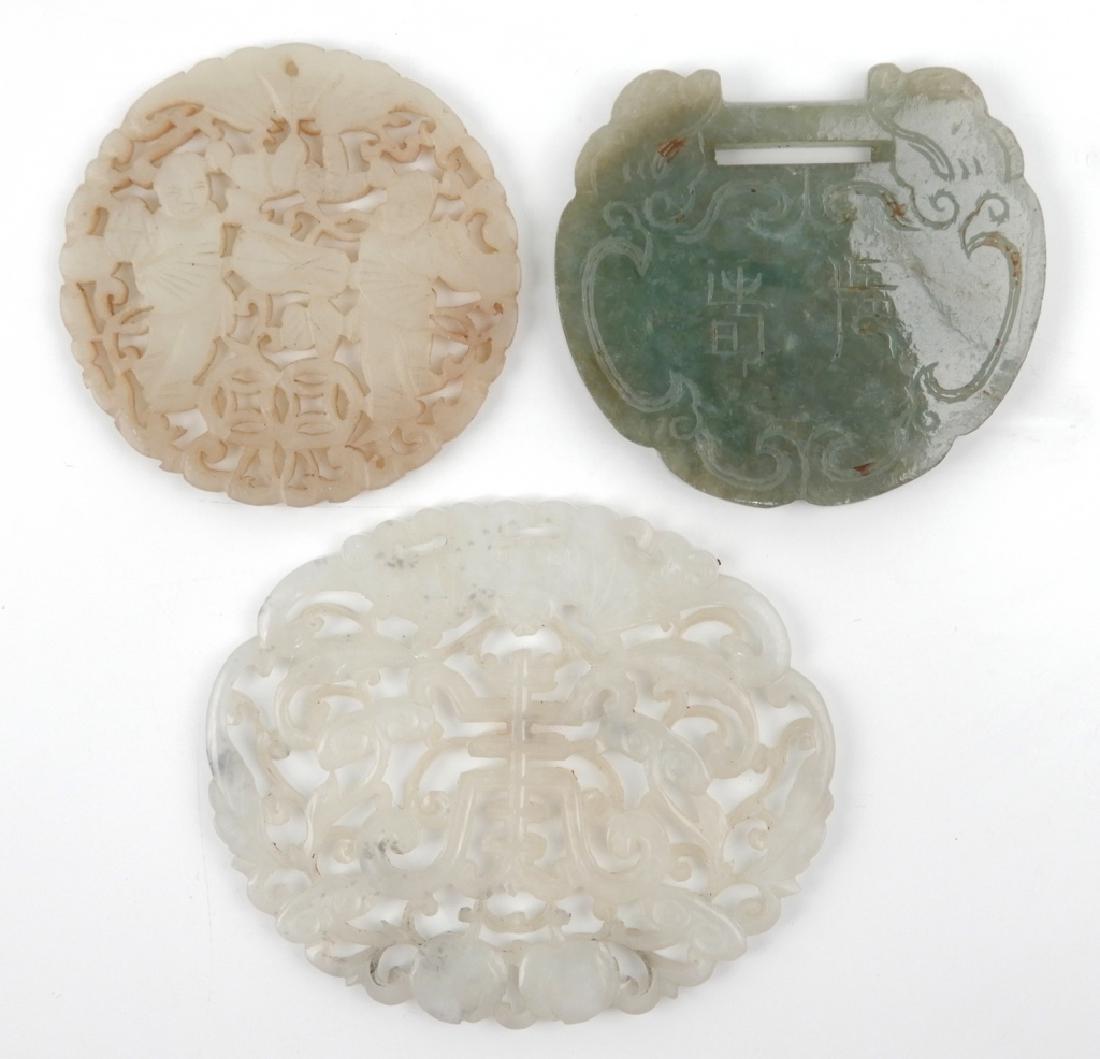 Three Chinese carved stone medallions: Three Chinese carved stone medallions, one round, 2 1/4" diameter, light green carved hard stone; one oval carved light green jade, 3" x 2 1/2"; and one green jade drop with etching, 2 1/4" x 2", mid
