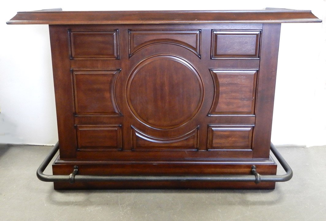 Cherry bar with leather style top: Cherry bar with leather style top, paneled front and sides, spelter foot rest, interior with stainless drysink, two short drawers, wine rack and storage, 43" x 62" x 27"