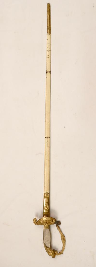 Bavarian Official's Sword in scabbard: Bavarian Official's sword in scabbard, brass hilt with lions head, crossguard with figural scene, etched blade with gilt accents and blued panels, missing mother of pearl grips, leather scabbard with 