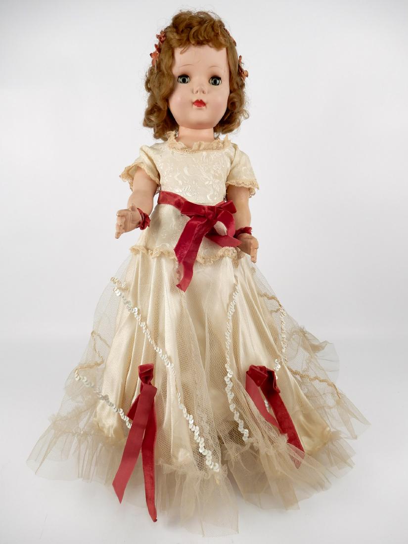 American Character hard plastic walker: American Character hard plastic walker, sleep eyes, applied upper lashes, painted lower lashes, eyebrows, closed mouth, marked Amer Character on head, wearing formal gown, measures 23" tall