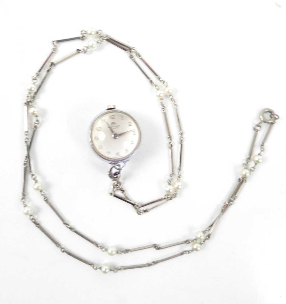 Lady's Bucherer skeleton pendant watch: Lady's Bucherer skeleton pendant watch, round shape, 21mm in diameter, silver tone metal, works marked Bucherer 15 jewels, 36" long silver tone chain with faux pearl stations
