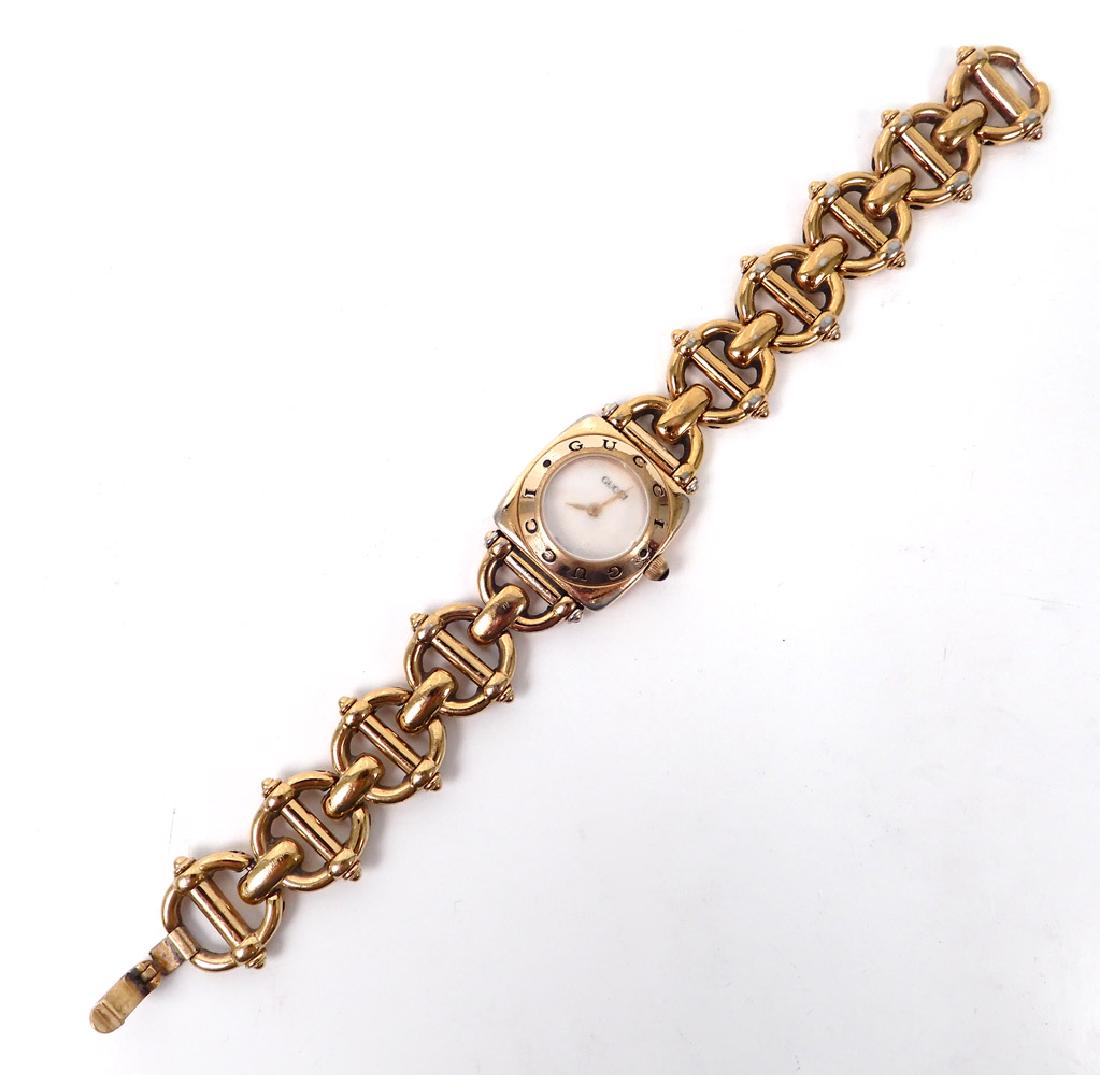 Lady's Gucci bracelet watch with box: Lady's Gucci bracelet watch with box, gold plated links with horse bit motif, square case with round face and impressed Gucci on bezel, 7" long, case is 7/8" wide, marked on back Gucci Water Resistant