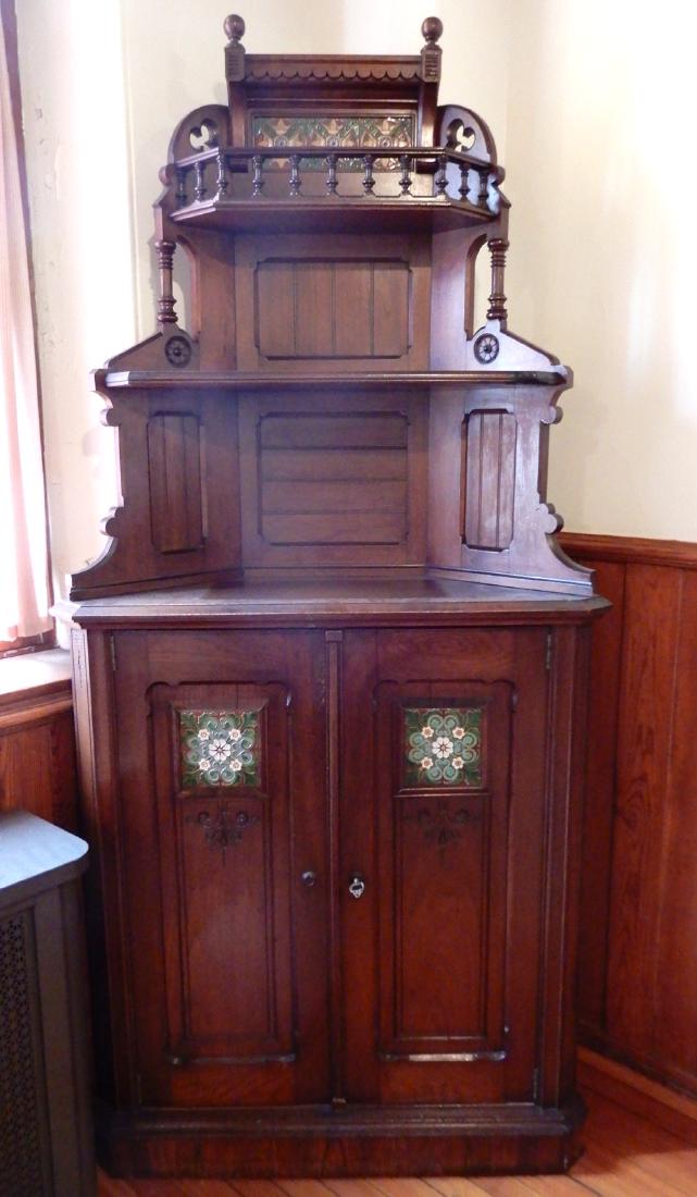 Walnut corner cabinet: Walnut corner cabinet, three tiered shelves over a pair of paneled doors, tiled backsplash on top shelf, tile insert on each door, molded base, ca. 1890, 87" x 41" x 26"