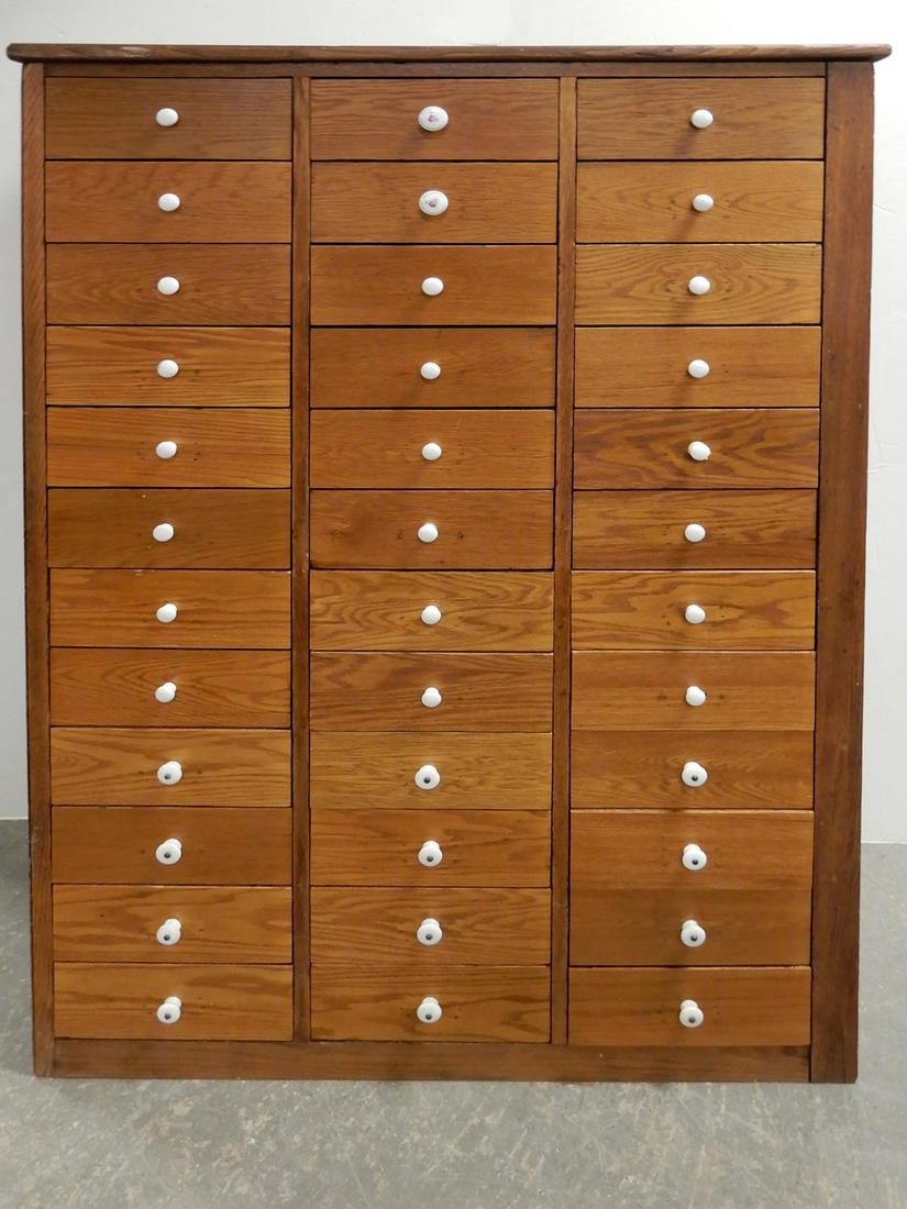 Chestnut apothecary cabinet: Chestnut apothecary cabinet, thirty-six drawers, porcelain knobs, raised panels on one side, tongue and groove back, 64 1/2" high x 44" x 20"