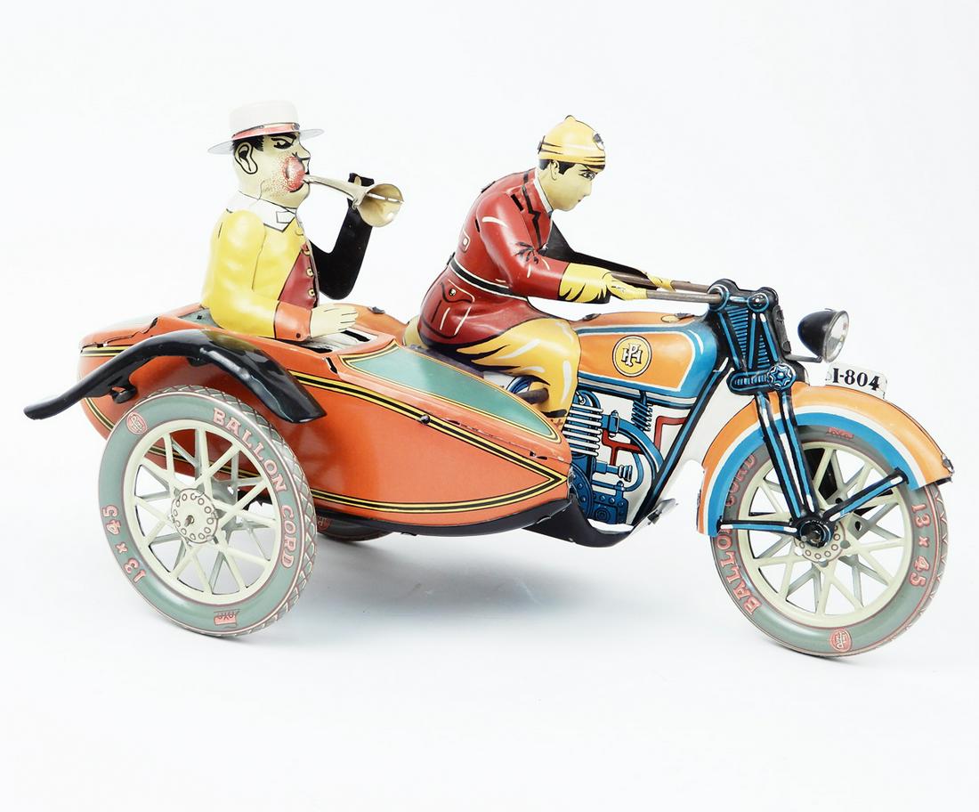 Modern era motorcycle with side car.: Modern era motorcycle with side car, measures 7" high x 11" long x 6" wide. Gas tank marked PH. Tires read Balloon Cord and PH, front fender marked # I-804 on it, no manufacturing marks, Has a putt-pu