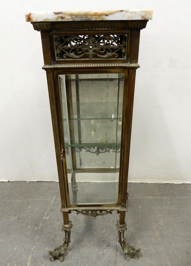 Brass and beveled glass marble top cabinet: Brass and beveled glass cabinet, marble top over pierced apron, single glass door, glass sides, mirrored back on four dolphin head feet, 37 1/2" (height) x 15 1/2" (length) x 14 1/2" (width)
