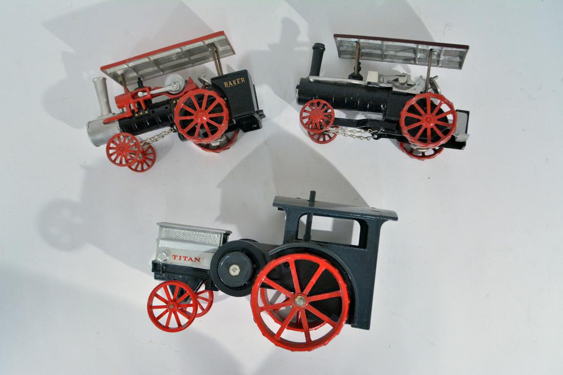 3 Modern cast replicas of steam driven: 3 Modern cast replicas of steam driven tractors, Heritage series. These are metal, the large piece seems to be pot metal and the smaller ones cast aluminum. The large one measures 10" long x 6" high x