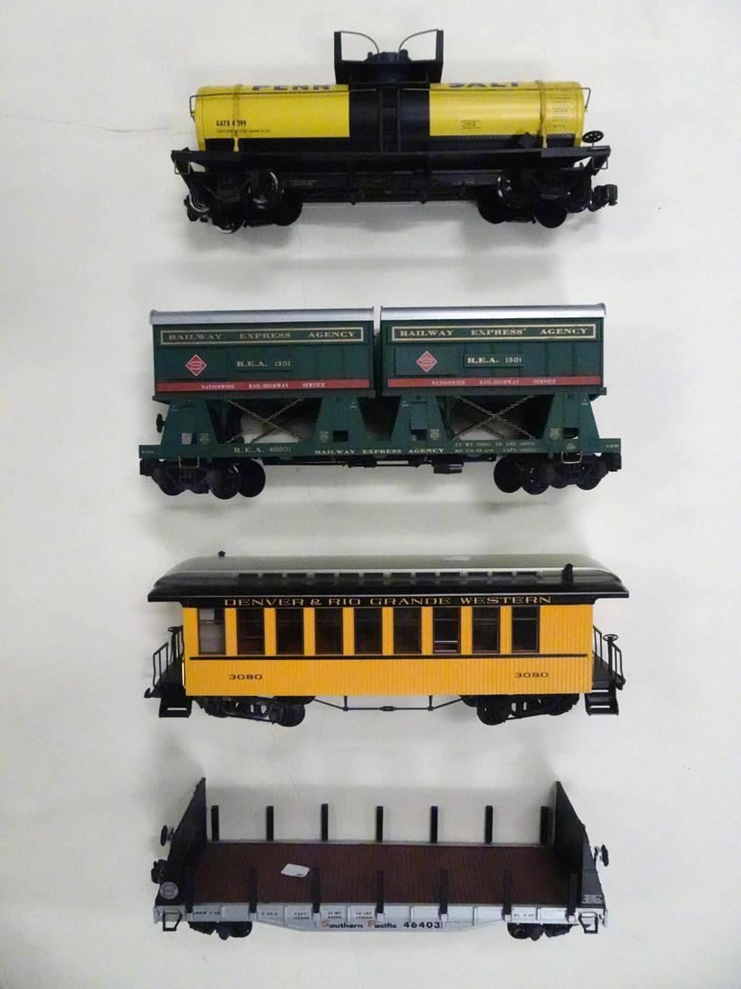 Four 1990's G gauge freight cars by various: Four 1990's G gauge freight cars by various manufacturers. There is a REA Express green flat car with containers, DRG&W yellow and black old time passenger car (chipped roof), a yellow Penn Salt tank 