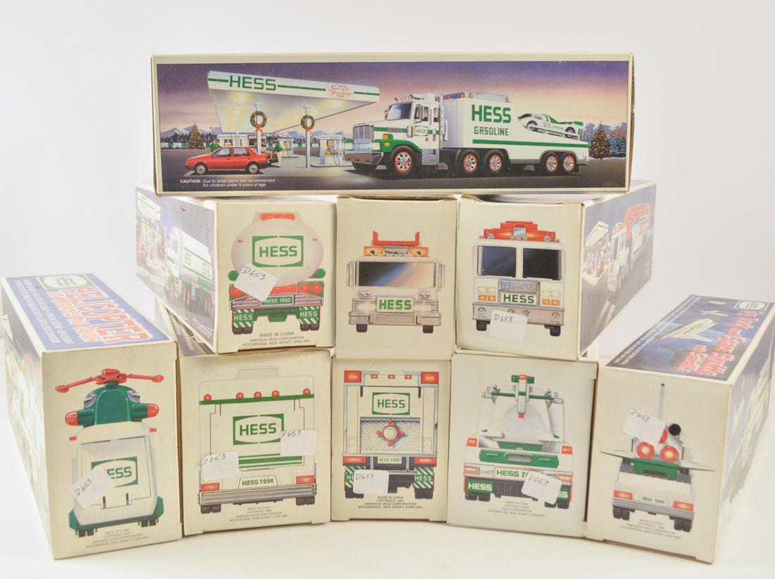 Nine 1990's-2000's Hess trucks in original boxes: Nine 1990's-2000's Hess trucks in original boxes. Trucks include two fire trucks, two trucks with helicopters, truck with spacecraft, tanker truck, RV with race car and motorcycle, flatbed with race c
