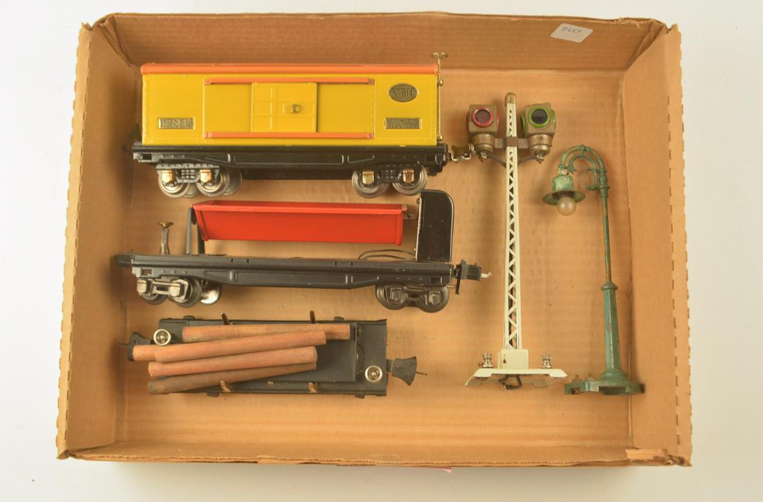 Three Lionel O gauge pre-war freight cars and two: Three Lionel O gauge pre-war freight cars and two Lionel pre-war platform accessories. The lot consists of a #814 yellow and orange that looks to be restored, a #3859 red and black side dump car, a #3