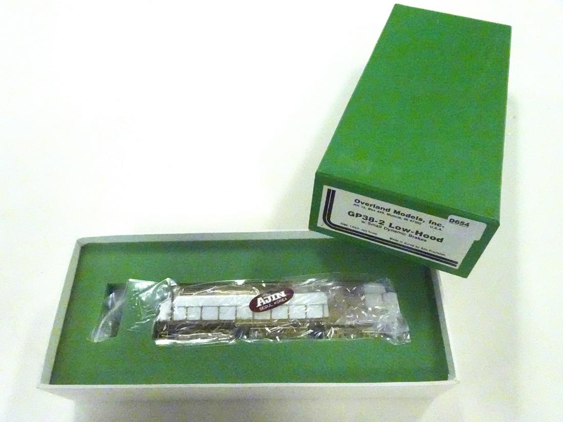 1990's Overland Models by AJIN (Korea) unpainted brass: 1990's Overland Models by AJIN (Korea) unpainted brass HO gauge GP-38-2 low hood diesel engine with small dynamic brakes in original box. Engine is still wrapped in factory plastic.
