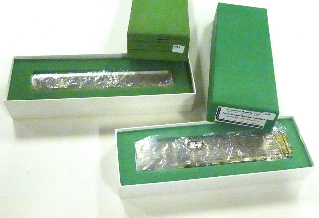 Two 1980's Overland Models by AJIN (Korea) unpainted: Two 1980's Overland Models by AJIN (Korea) unpainted brass HO gauge bi-level auto rack carriers, one open, one enclosed, in original boxes. Both cars measure a little over 12" long. One box missing en