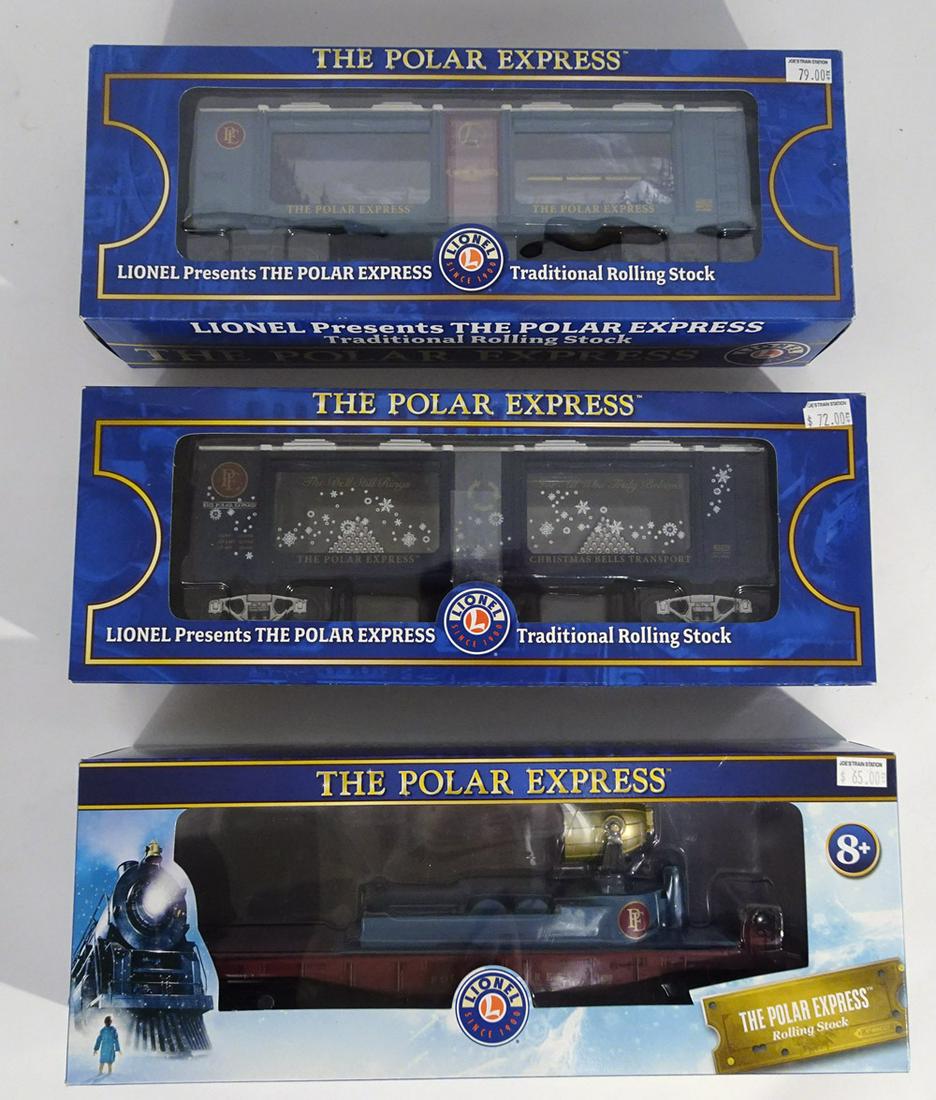 Three 2000's Lionel O gauge Polar Express add-on: Three 2000's Lionel O gauge Polar Express add-on freight cars in original boxes. Lot consists of #83239 PE Christmas Bells Transport Mint car, #1928420 PE searchlight car, and #82510 PE operating aqua