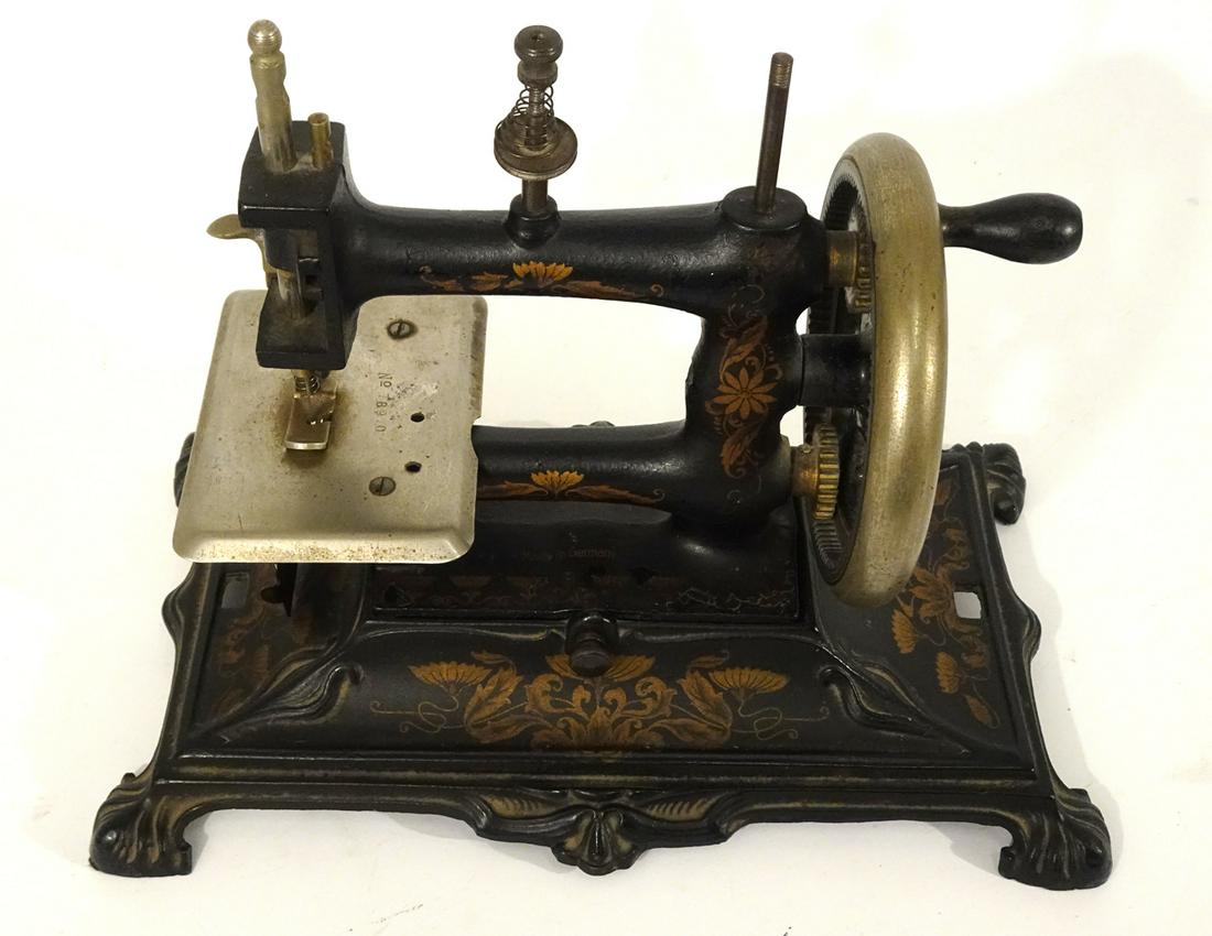 Large 1920's German cast iron and pressed steel table: Large 1920's German cast iron and pressed steel table top hand crank sewing machine. Machine measures 11" wide X 8" high. Appears complete. Black painted decaled base.