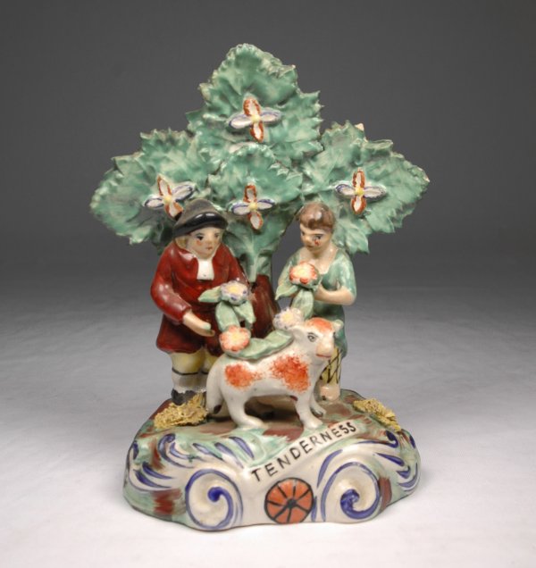 Staffordshire figural grouping, a couple with flora: Staffordshire figural grouping, a couple with floral garland and lamb, stand in front of bocage with the word "tenderness" on front of base. Back impressed Walton, (John Walton, Burslem, England), ear