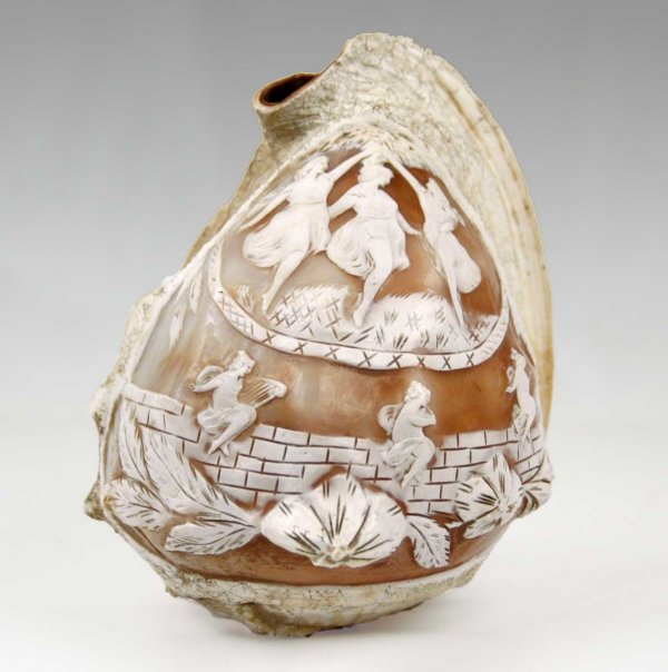Cameo carved conch shell, 7 1/2" long, mythologica: Cameo carved conch shell, 7 1/2" long, mythological scene, mid 20th C., 1 1/2" hole on bottom for light fixture, two small holes on side, crack on edge of scene