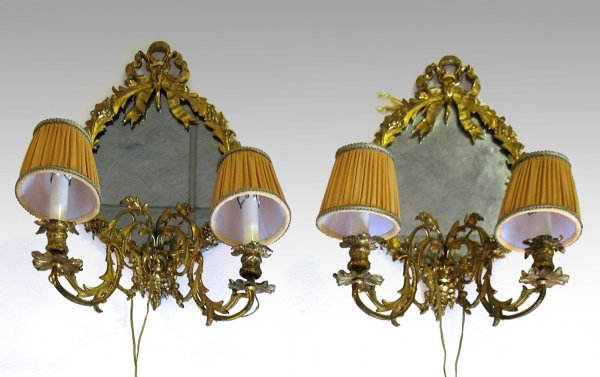 Pair of bronze dore English sconces, mirrored back: Pair of bronze dore English sconces, mirrored back with gilt bronze swirl, foliate and berry frame, ribbon crest, two S- shaped pierced arms extend out from base, each terminating in candlelamp with c