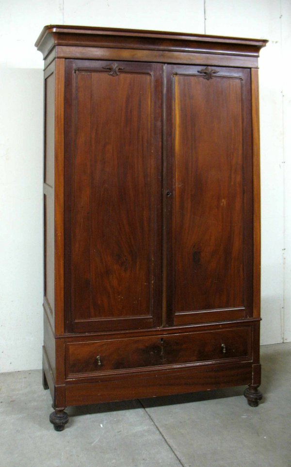 Mahogany double door armoire, overhanging cornice : Mahogany double door armoire, overhanging cornice over a pair of paneled doors, each with applied crest over one long drawer, above one long hidden drawer, front turned feet, mid to late 19th C., 80 1